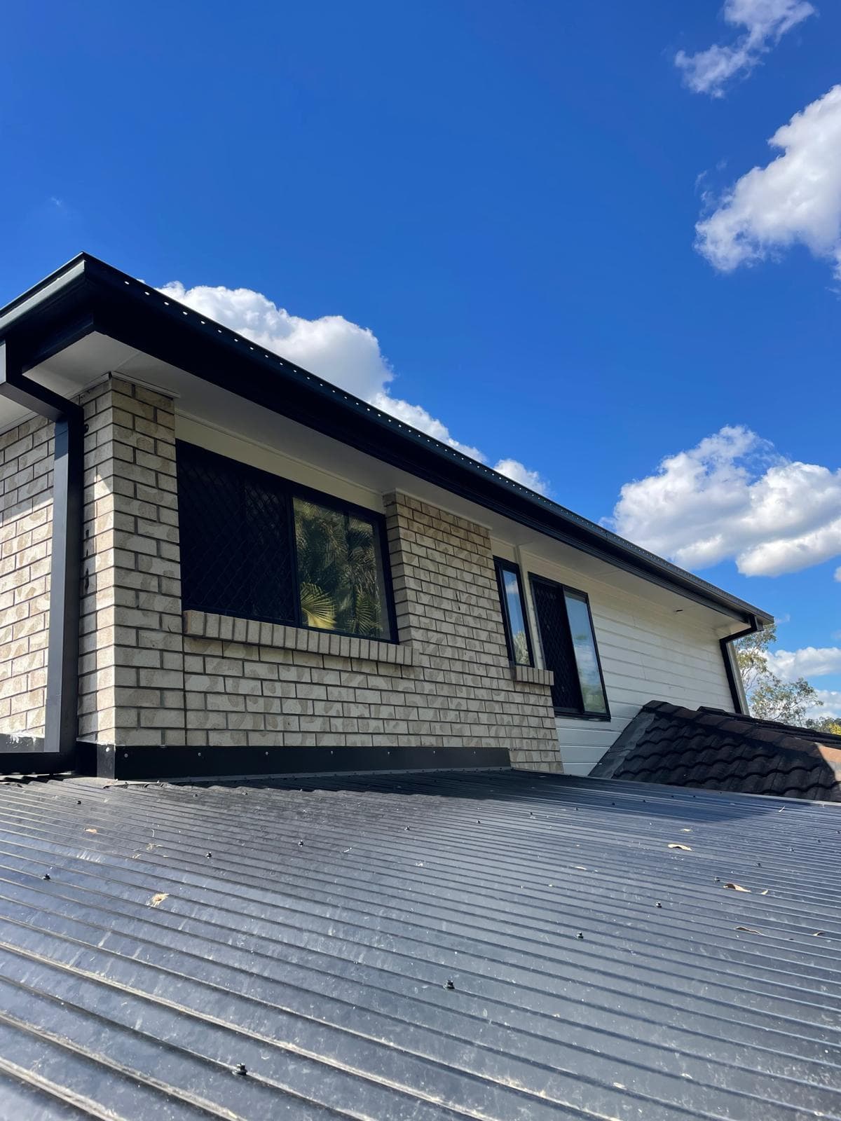 Modern brick and weatherboard exterior meeting a metal roof